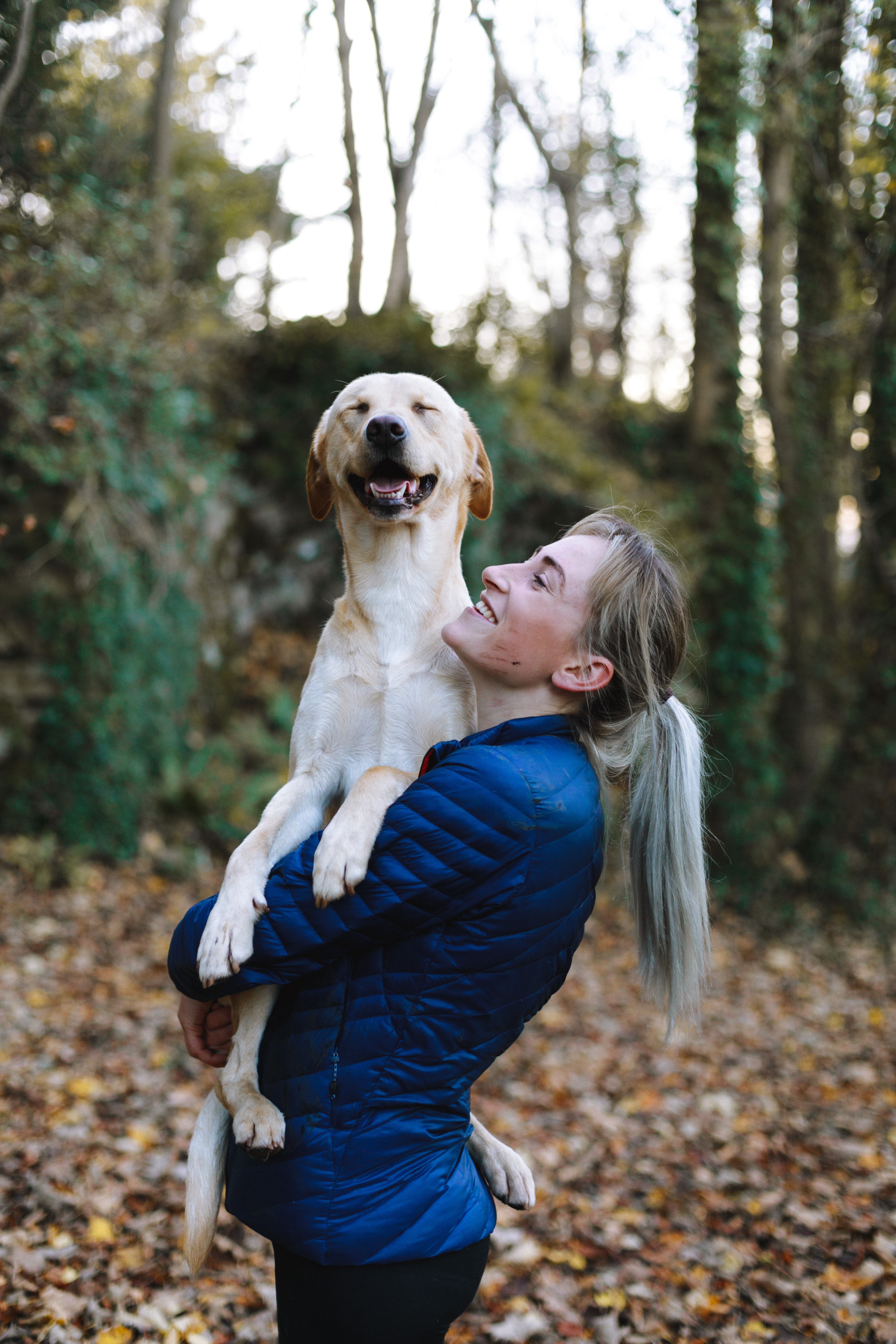 Women in forest holding dog